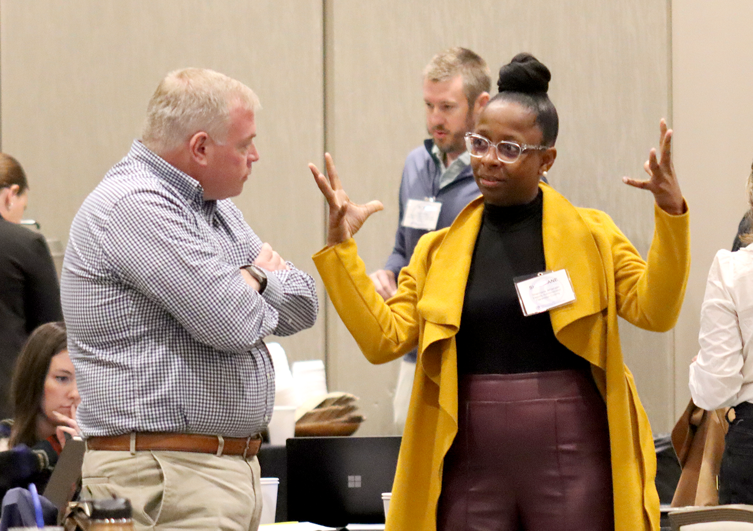 A woman gestures while speaking to a man during the 2024 Local Government Attorneys' Institute.